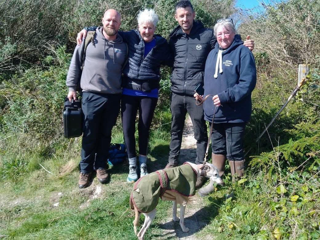 Eye In The Sky volunteers and a reunited dog on a coastal path after a successful search