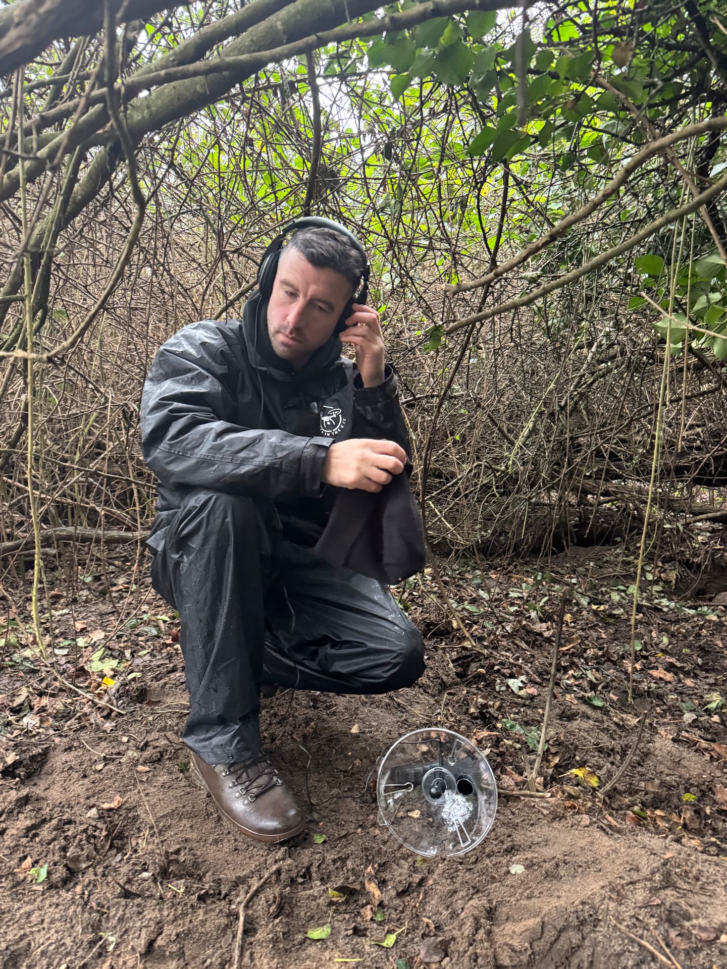 Dave Rimmer using a parabolic microphone to listen for a lost dog in dense woodland